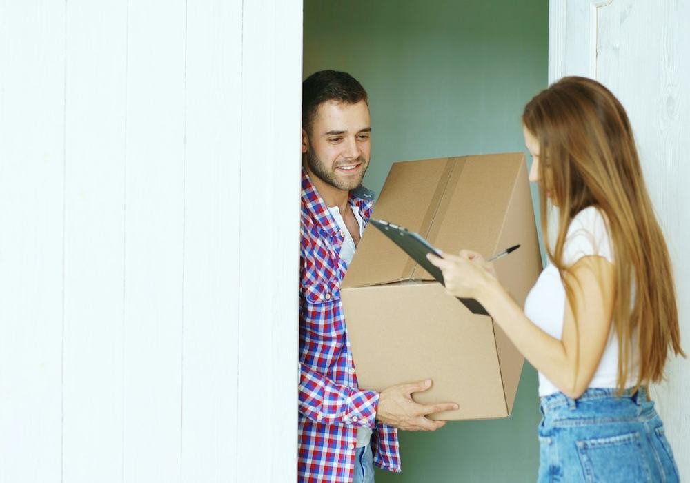 A courier handing a parcel to a customer at the door