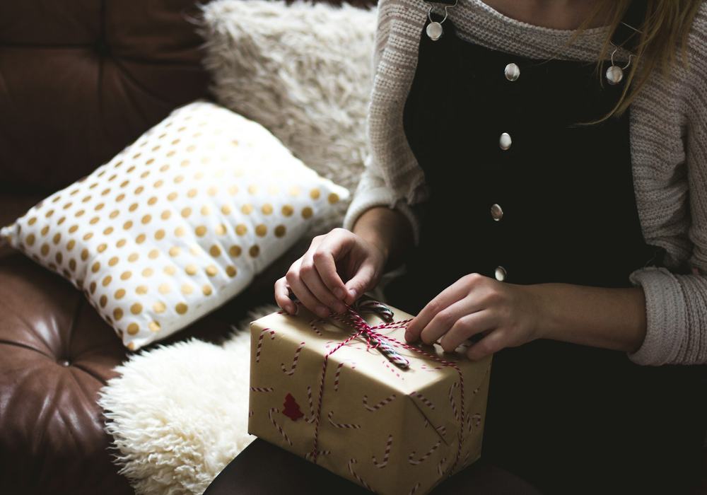 A customer opening a parcel on a sofa